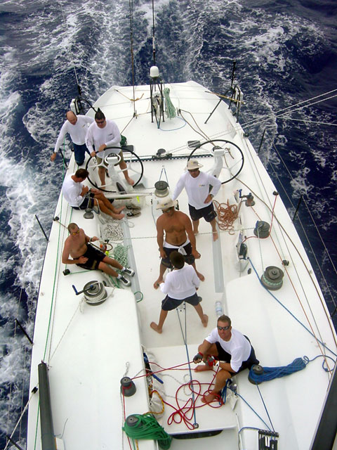 Afternoon watch in the trades. From the stern, Ed talking about the weather, Philippe steering, Madro mainsheet, Kevin on standby grinding the mainsheet, Dave trimming the kite, Tony and Shark grinding the kite, Freddy tailing Doogie up the mast.